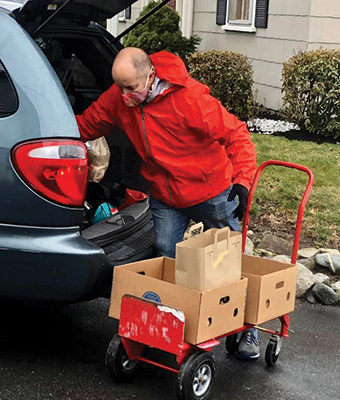 Volunteer loading up a car with food