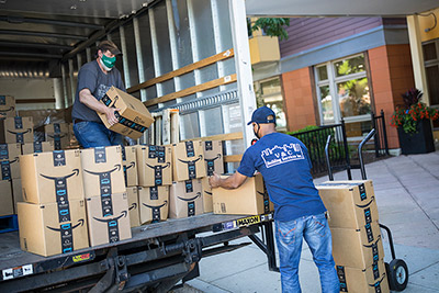 Delivery men unloading boxes of food