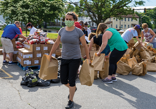 Volunteer handing out food at Lowell pantry