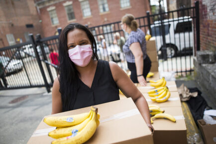 Woman with a box of food and bananas