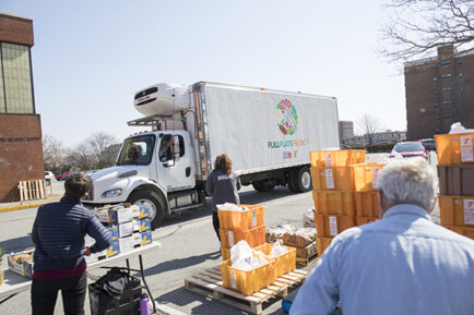 Full Plate Project truck and bags of food ready for distribution.