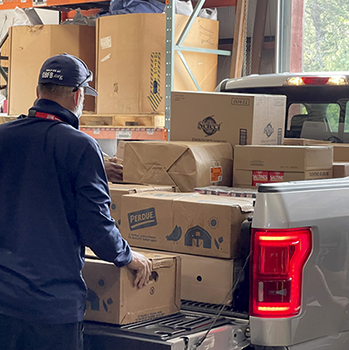 GBFB team member unloading boxes of food from a truck bed