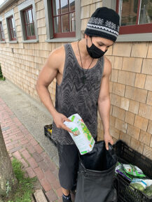 Nantucket Food Pantry client Youssef filling a bag with food