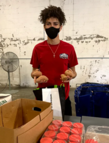 A YMCA Boston staff member sorting potatoes