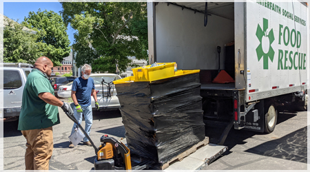 Interfaith Social Services unloading a palette of food from their truck.