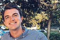 Young man poses for photo with trees in background