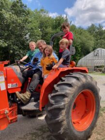 4 children and an adult sitting on a tractor